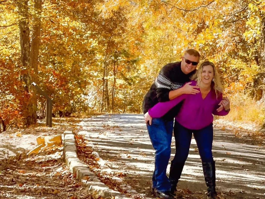 couple surrounded by fall leaves