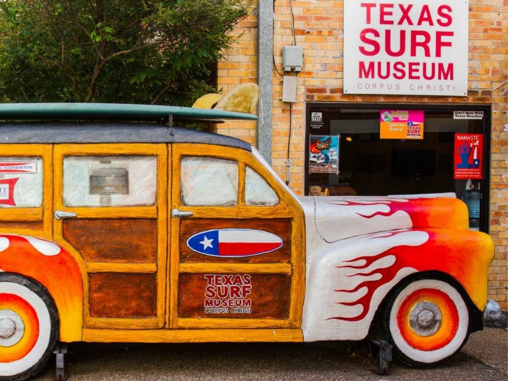 old car in front of the surf museum