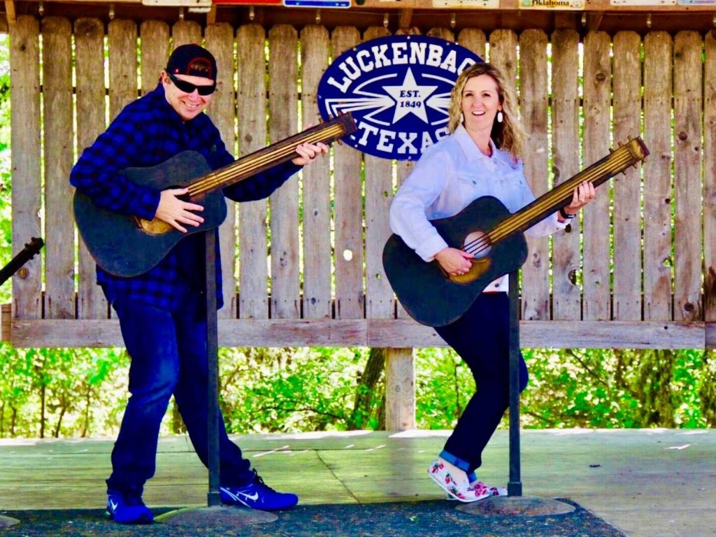 couple playing guitars on stage in Luckebach