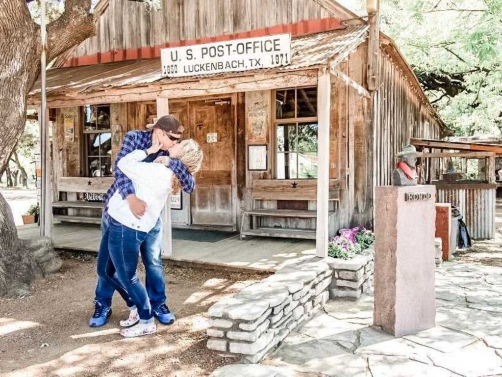 couple dip kissing in front of Luckenbach post office